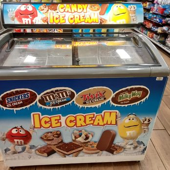 Sheetz - an ice cream machine in a store - A commercial ice cream freezer featuring branding for Snickers, M&M's, Twix, and Milky Way, with colorful M&M's characters on the front. - Convenience Stores Near Me - Wadsworth, Ohio
