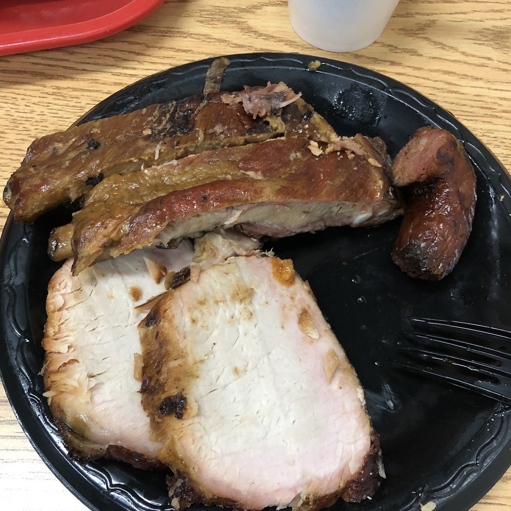 ows a plate of meat and a side of beans
