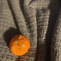 a single orange on a blanket a single orange on a blanket