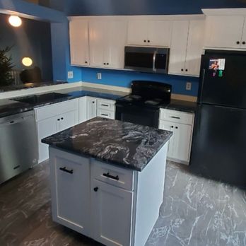 Meier Contracting - a kitchen with white cabinets and black appliances - Carpenters Near Me - Johnstown, Colorado