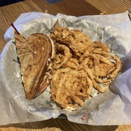 Half of a Reuben and onion rings. Half of a Reuben and onion rings.