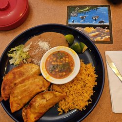 Los Compadres Mexican Restaurant - Birria tacos with refried beans and rice and a cup of dipping consomme .