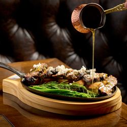 Blaqcat Ultra Lounge and Cuisine - A juicy ribeye steak, sizzling hot and perfectly seared, delivering bold flavors with every bite.