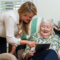 Tapestry House Assisted Living - Our Marketing Director showing a resident how to use her ipad and facetime with her family