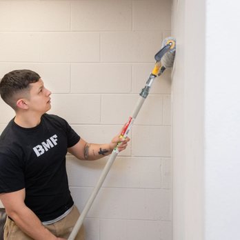 BMF Remodeling - a man in a black t - shirt and khaki pants holding a paint roller - General Contractors Near Me - Oswego, Illinois