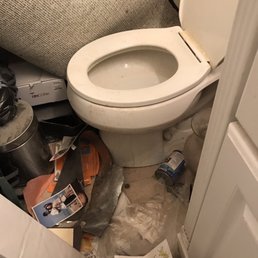 a toilet in a cluttered bathroom