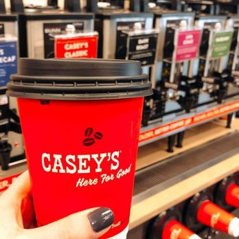 Casey's - a person holding a cup of coffee - Pizza Near Me - Kingfisher, Oklahoma
