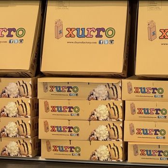 Xurro - Boxes - Multiple boxes of Xurro dessert, featuring ice cream and toppings, are stacked on a shelf in a store. - Desserts Near Me - Burbank, Illinois
