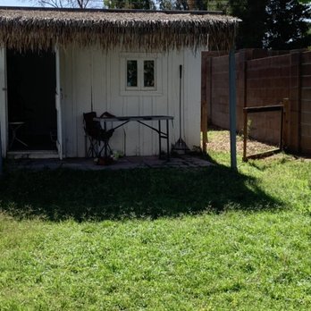 Desert Coral Landscaping  -  white shed with a thatched roof - Landscaping Near Me