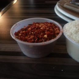 Plastic cups of hot peppers and parmesan served with our pizza.