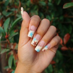 Butter yellow French tip with brown and blue stars.