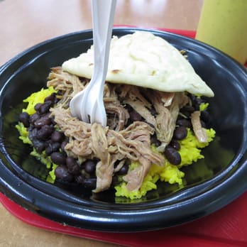 Tropical Grille - Cuban Roasted Pork Chop - 12-hour marinated slow roasted pork with yellow rice, black beans, and a small slice of pita bread. - Cuban Near Me - Greenville, South Carolina Tropical Grille - Cuban Roasted Pork Chop - 12-hour marinated slow roasted pork with yellow rice, black beans, and a small slice of pita bread. - Cuban Near Me - Greenville, South Carolina