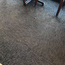 Trash and crumbs on the floor all throughout the restaurant. Trash and crumbs on the floor all throughout the restaurant.
