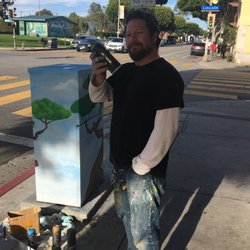 Roosevelt Elementary School - Sel (@Sel_Dog) painting a utility box Catty corner from the school. Matches the building behind him.