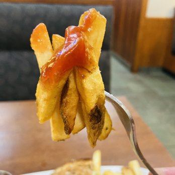 White Spot Kingsway - a hand holding a fork with fries and ketchup - American Near Me - Vancouver, British Columbia White Spot Kingsway - a hand holding a fork with fries and ketchup - American Near Me - Vancouver, British Columbia