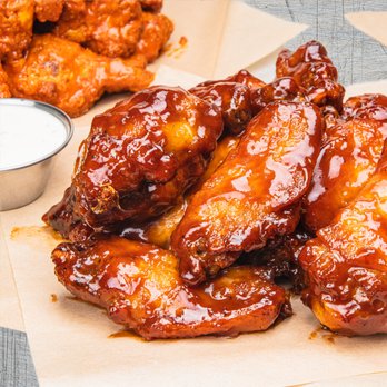Wing Squad - a pile of chicken wings and a bowl of sauce - Food Delivery Services Near Me Wing Squad - a pile of chicken wings and a bowl of sauce - Food Delivery Services Near Me