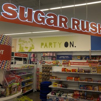 Five Below - Candy! - Candy shelves are visible under a large, illuminated sign that says 'SUGAR RUSH.' The store has colorful displays and promotional signs for candy deals. - Discount Store Near Me - Littleton, Colorado