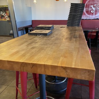 Fired Pie - a wooden table in a restaurant - Pizza Near Me - Phoenix, Arizona Fired Pie - a wooden table in a restaurant - Pizza Near Me - Phoenix, Arizona