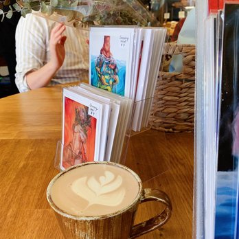 Wicked Cafe - a cup of cappuccino with a woman in the background - Cafes Near Me - Vancouver, British Columbia Wicked Cafe - a cup of cappuccino with a woman in the background - Cafes Near Me - Vancouver, British Columbia