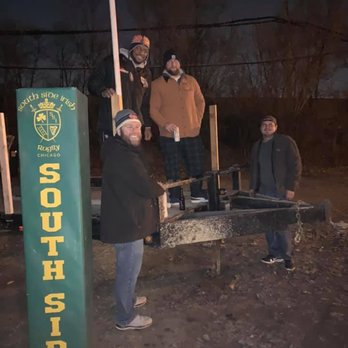 Front Row - a group of people standing in front of a sign - Sports Bars Near Me - Blue Island, Illinois