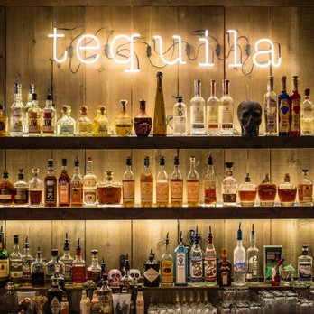 Blanco Cantina - a shelf of tequila bottles - Bars Near Me - Calgary, Alberta