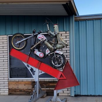 Rickety Cricket Brewing - a man riding a motorcycle on a ramp - Pizza Near Me - Kingman, Arizona