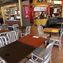Raising Cane's Chicken Fingers - Dining area and note bench near counter for waiting on to-go orders.