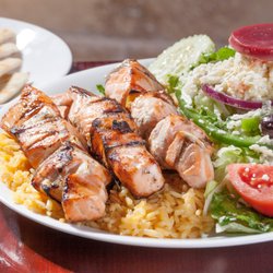 Little Greek Fresh Grill - Windermere - Three char-grilled salmon skewers over rice accompanied with our fresh Greek salad. Served with warm pita bread and tzatziki sauce.