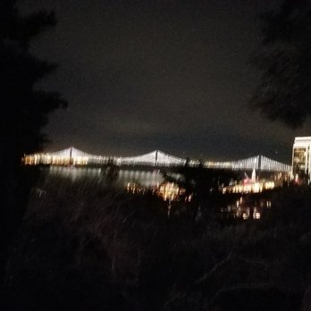 Coit Tower - The Oakkand Bay bridge lit up at Christmas time as seen from Coit Tower. - Landmarks & Historical Buildings Near Me - San Francisco, California