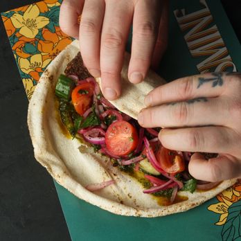 Yasmine - a person putting a piece of food on a tortilla - Kebab Near Me - Chevy Chase, Maryland