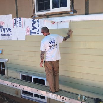 Top Notch Construction - a man standing on the side of a house - General Contractors Near Me Top Notch Construction - a man standing on the side of a house - General Contractors Near Me