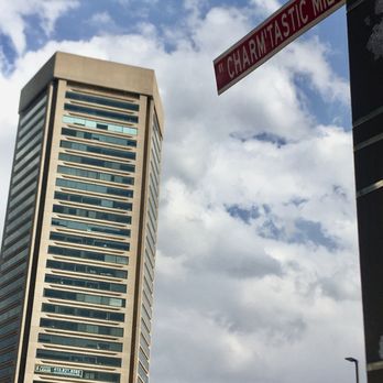 Visit Baltimore - The World Trade Center in the background of the Iconic "Charm'tastic Mile" Street Sign. - Public Art Near Me - Baltimore, Maryland Visit Baltimore - The World Trade Center in the background of the Iconic "Charm'tastic Mile" Street Sign. - Public Art Near Me - Baltimore, Maryland