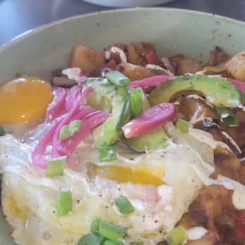 First Watch - A breakfast plate featuring fried eggs with runny yolks, sliced avocado, pickled red onions, chopped green onions, and diced potatoes. - Cafes Near Me - Tucson, Arizona