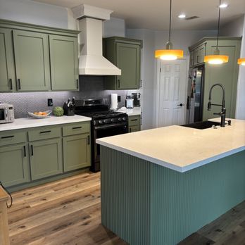 Sanchez Coatings - Contrast and color! The custom green cabinetry pops beautifully against the white countertops and modern fluted island. - Painters Near Me Sanchez Coatings - Contrast and color! The custom green cabinetry pops beautifully against the white countertops and modern fluted island. - Painters Near Me