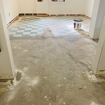 Elite Floor Covering - an empty room with a checkered floor - Flooring Near Me