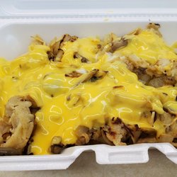 Fries covered with fried onions, mushrooms and chicken with nacho cheese sauce