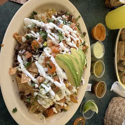 Supreme nachos . The sauces go from hottest to the left down to mild to the right