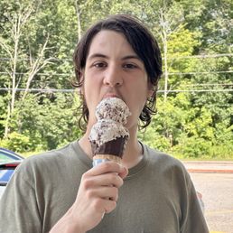 Teenager enjoying cow print ice cream in a dipped cone. Teenager enjoying cow print ice cream in a dipped cone.