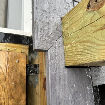 J White Construction - The image shows a close-up of wooden and metal surfaces with water droplets, likely outdoors after rain. - Roofing Near Me - Wilmington, Massachusetts