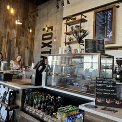 Foxtail Coffee - Where they take your order. Also showing their food display case, bottled drinks, pickup area, and barstool seating.