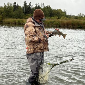 Kulik Lodge - Our fishing guide getting the hook out of the fish's mouth carefully. - Fishing Near Me - Anchorage, Alaska
