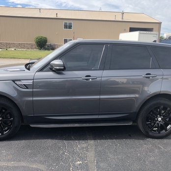 Creative Powder Coatings - A gray Range Rover SUV with tinted windows and black wheels is parked in a parking lot near a beige industrial building with a small shrub. - Powder Coating Near Me - Crest Hill, Illinois