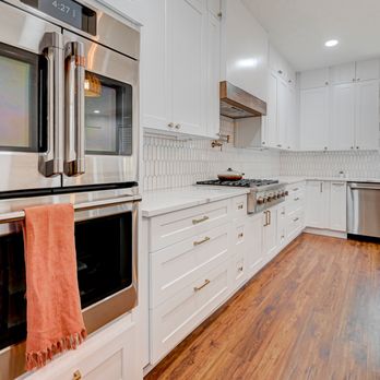SK North Carolina Constructions - a kitchen with white cabinets and stainless steel appliances - General Contractors Near Me SK North Carolina Constructions - a kitchen with white cabinets and stainless steel appliances - General Contractors Near Me