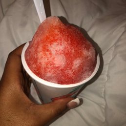 a hand holding a cup of frozen fruit a hand holding a cup of frozen fruit