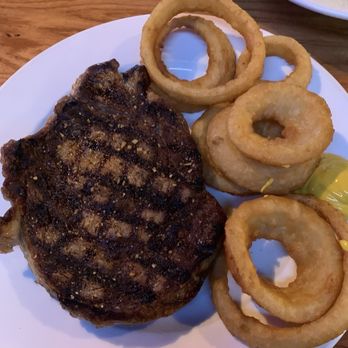 Uptown Cafe & Club D'Est - Charbroiled medium rare ribeye with onion rings - American Near Me - Pratt, Kansas Uptown Cafe & Club D'Est - Charbroiled medium rare ribeye with onion rings - American Near Me - Pratt, Kansas
