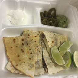 quesadillas and lime wedges in a styrofoam container