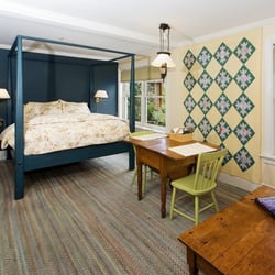 Annie's Cottage - The queen sized feather bed is adorned with down pillows and a comforter.