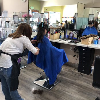Li'l Couture Salon - Kids enjoying the movie and haircut. Glitter hair tinsel hanging on the glass. - Kids Hair Salons Near Me - San Carlos, California