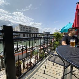 a man sitting at a table on a balcony a man sitting at a table on a balcony