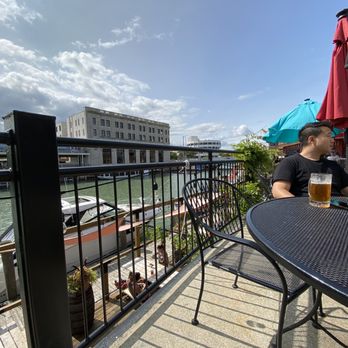 Wings Etc - a man sitting at a table on a balcony - Chicken Wings Near Me - Port Huron, Michigan Wings Etc - a man sitting at a table on a balcony - Chicken Wings Near Me - Port Huron, Michigan